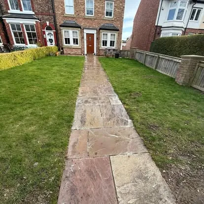 The same stone path after cleaning, lighter restored slabs
